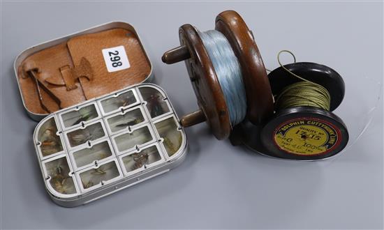 A mahogany and brass fishing reel and a case of fishing flies